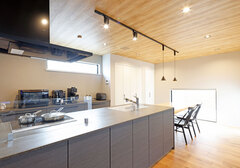 明るい木目調の天井が印象的なキッチン。広々としたスペースで調理を楽しめる。モダンなペンダントライトが空間をスタイリッシュに演出