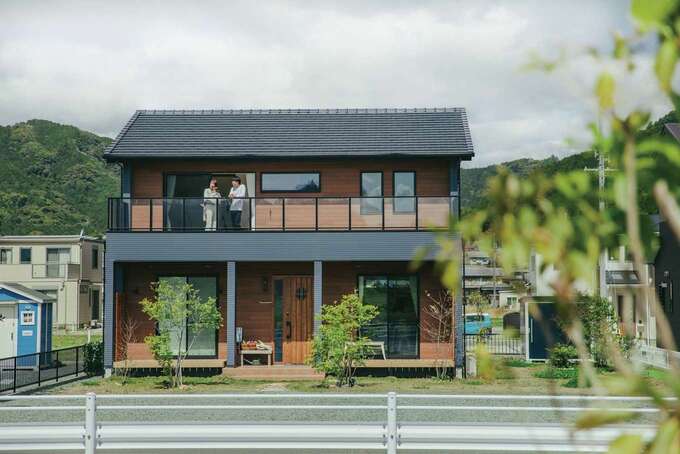 子育て安心住宅 Design Craft Office｜木目を基調に濃いグレーを組み合わせた外観が背景の山々と調和している