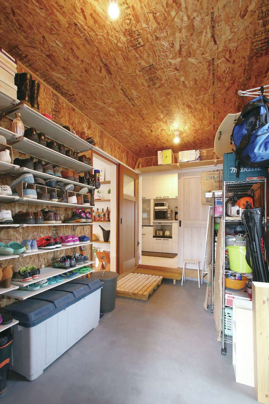 片桐建設【間取り、デザイン住宅、省エネ】キャンプ用品などのアウトドアグッズもすっぽり収まる玄関クローク。OSB合板を貼ってニュアンスを出した。パントリー、キッチンヘも直結して便利