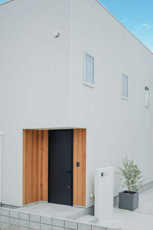 玄関回りにレッドシダーを採用してアクセントを。道路からの視線をカットするため、間取りや窓配置を工夫した