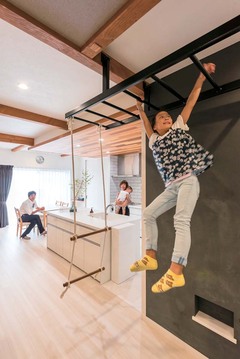 うんていはカジュアルになりすぎないよう黒色に。上り口はあえて作らずブランコで兼用とした。後ろの壁はお絵かきできる黒板になっている