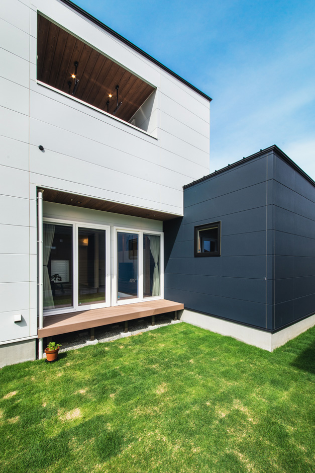 SEIEN ARCHITECT【省エネ、建築家、ガレージ】バイクガレージで道路側の視線を遮り、プライバシーを確保した中庭。掃出窓に沿ってウッドデッキも設けてある。夏はデッキでお酒を飲むのが夫妻の楽しみ