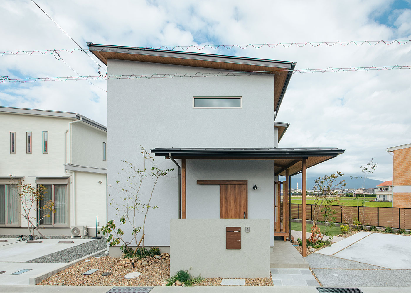 フジモクの家（富士木材）【自然素材、狭小住宅、省エネ】シンプルなフォルムと展示場を参考にしたグレートーンの外壁色により、正面はモダンな印象。軒天やデッキの木の風合いがぬくもりを添えている