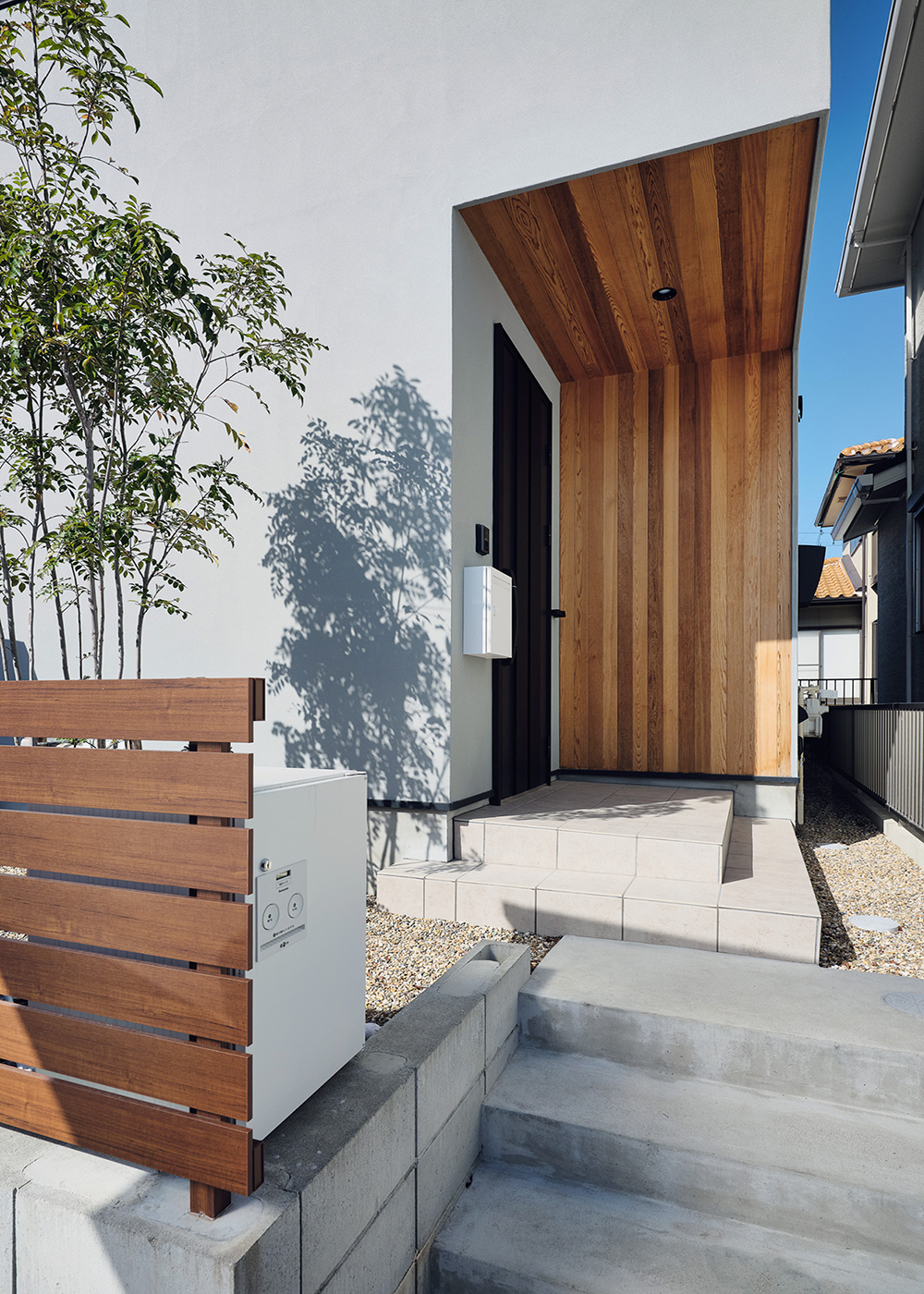 平屋建築ブルーハウス【デザイン住宅、間取り、ペット】玄関ポーチの壁や天井にはレッドシダー張りを採用。塗り壁の外壁にマッチした上質な素材を使用し、品質・デザイン共に調和の取れた外観が実現