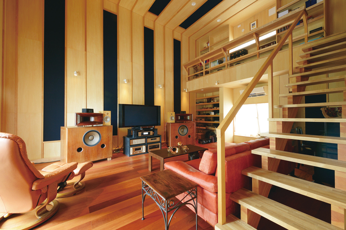 リビングを兼ねたオーディオルームは、趣味を楽しむと同時に「くつろぎの場所」でもある。友人をもてなすのも食後の団欒もここ。食事と睡眠以外のほとんどの時間を過ごす。階段を上がると夫婦の居住スペースへ