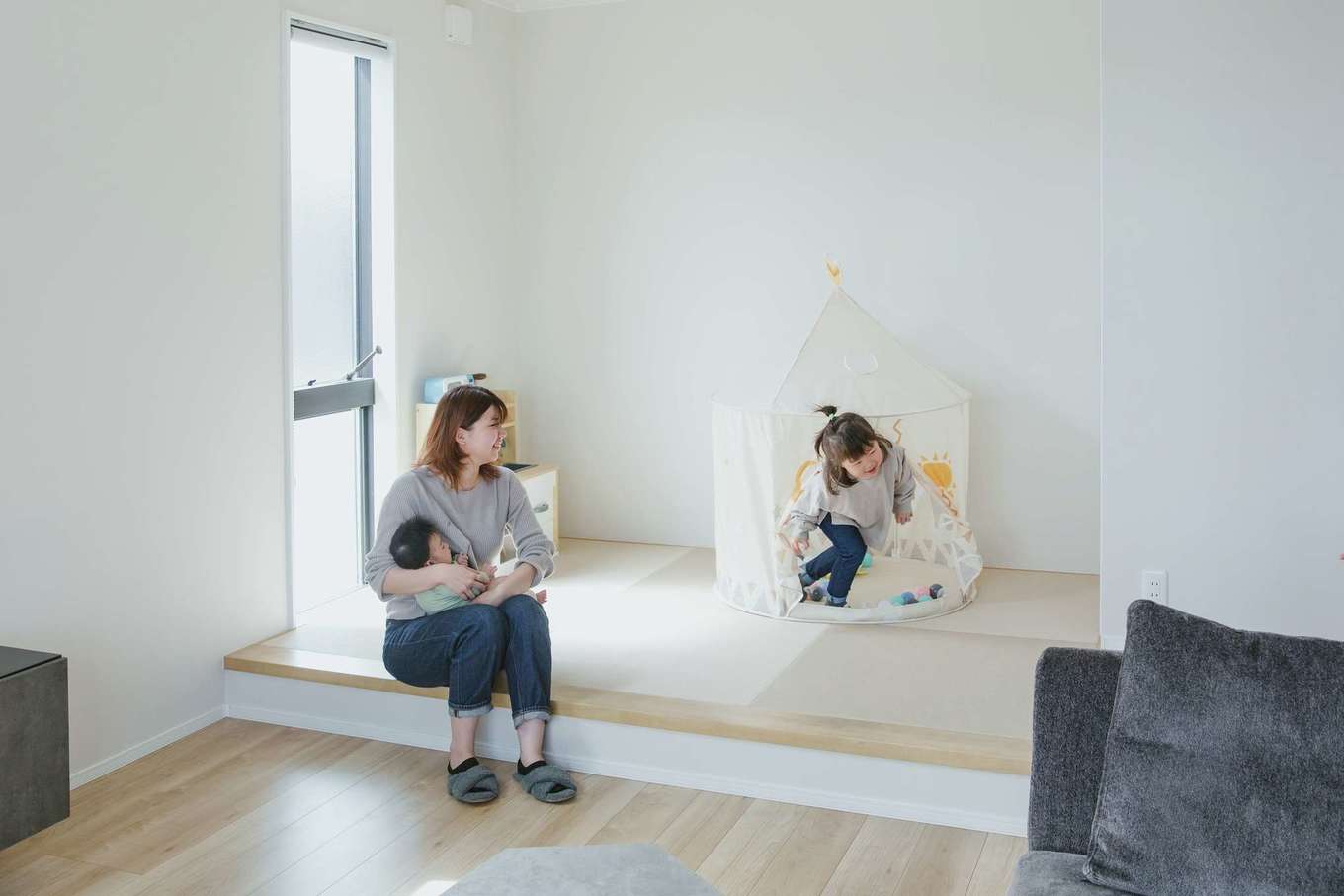 Yamaguchi Design 掛川店（アイフルホーム 掛川店）【デザイン住宅、子育て、間取り】ピットリビングの脇に設けた小上がりはキッズスペースとして大活躍。畳敷きで転んでも痛くないので、座り込んだり寝転がったり、自由な体勢で遊ぶことができる。小上がりの段差は腰掛けるのにちょうどいい高さ。子どもが遊ぶ様子を見守りながらの手仕事にも便利。