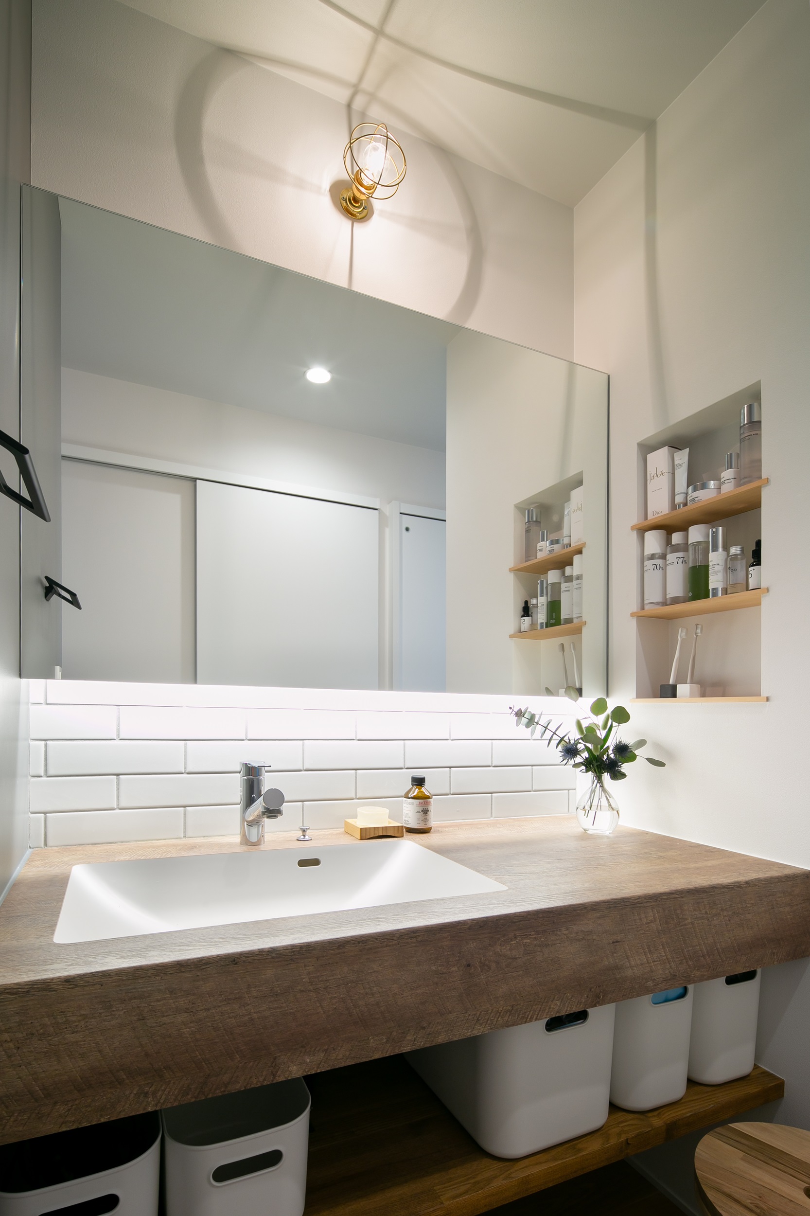 シンプル｜一面鏡でスタイリッシュに仕上げた洗面コーナー。
どこからでもアクセスがしやすいよう、お家の中心に設置。