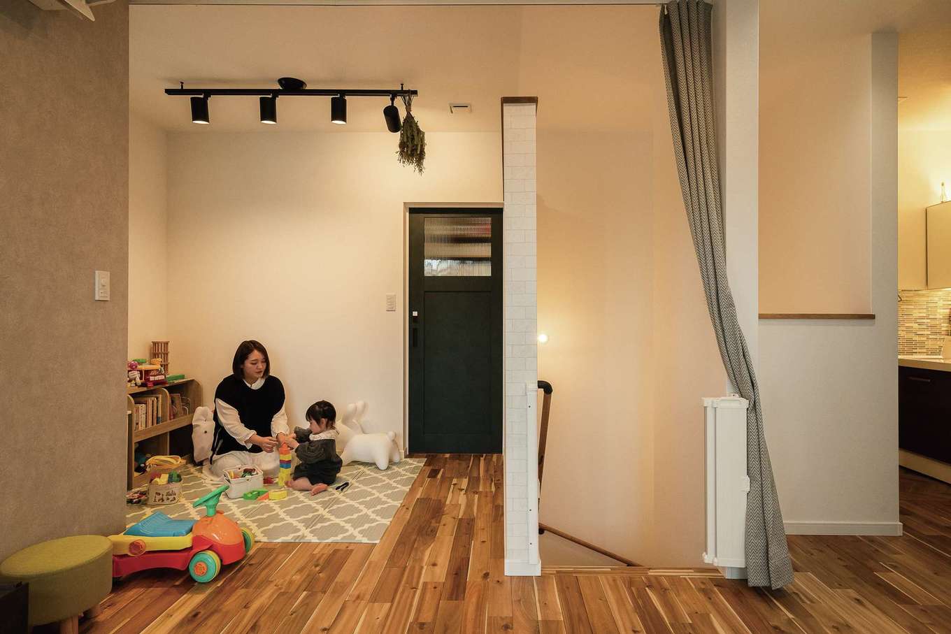 三和建設【デザイン住宅、子育て、間取り】キッチンから目の届く位置に設けた3.5畳のキッズスペース。おもちゃがリビングに散らかることがなく、いつもスッキリ。奥の扉を開けると水回りで、キッチンまでぐるりと回遊できる