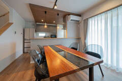 「無垢の一枚板のテーブルを置くことは最初から決めていたため、それに合わせてインテリアコーディネーターさんに配色や照明の当て方などを提案してもらいました」とご主人。グレーの下がり天井を採用し、照明にもこだわって、特別感のある空間に