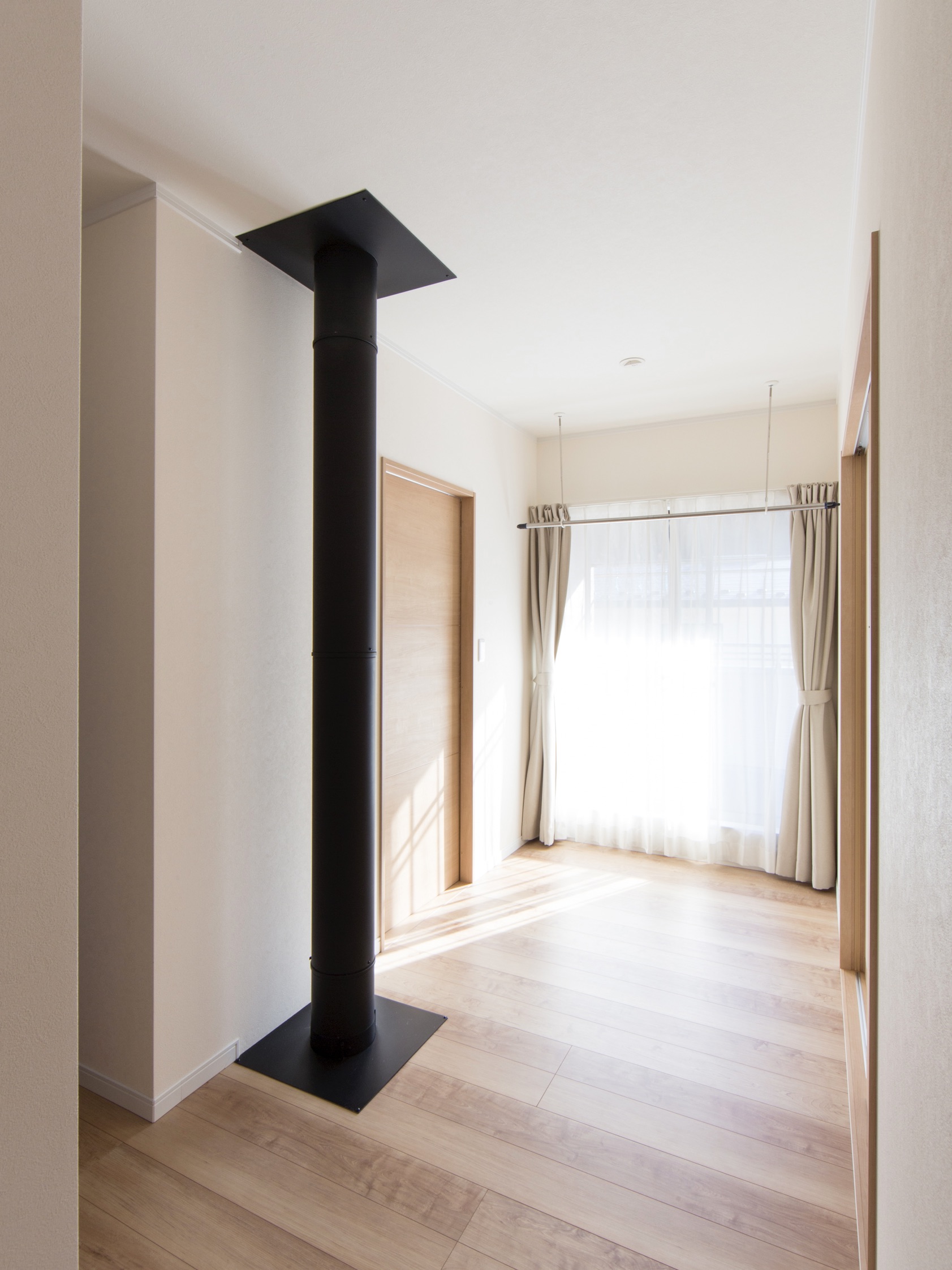 エスホーム｜薪ストーブの配管が通る２階ホール。日当たりがいいので、夏場はもちろん冬場はストーブの予熱もあり室内干し場として重宝する。