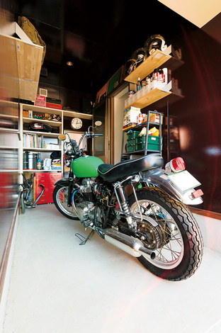 ご主人念願のガレージ。愛車のお手入れ用具や雑誌を並べる可動棚を取り付けた。より作業がしやすいよう、現在は自らカスタマイズ中