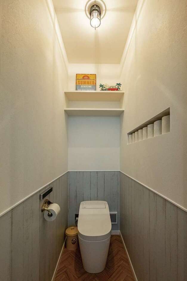 木目調のクロスとこだわりのペーパーホルダーなどどが上品でやさしい雰囲気のトイレ。ペーパーニッチや棚も依頼