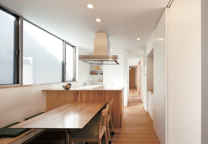 リビングの裏に位置するダイニングキッチン。リビングとの仕切りとなる壁は収納スペースで、冷蔵庫や調理家電を隠し、生活感を出さない