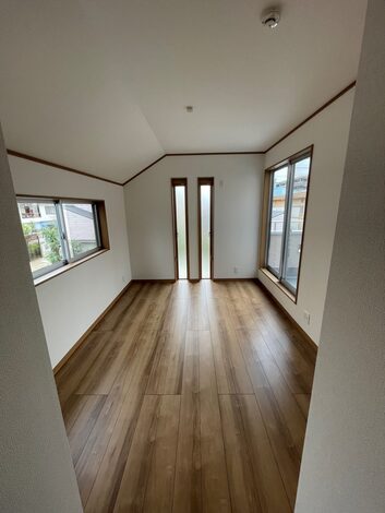 窓から差し込む自然光が心地よい居室の一角。落ち着いた床材とシンプルな壁面が空間に広がりを与えている