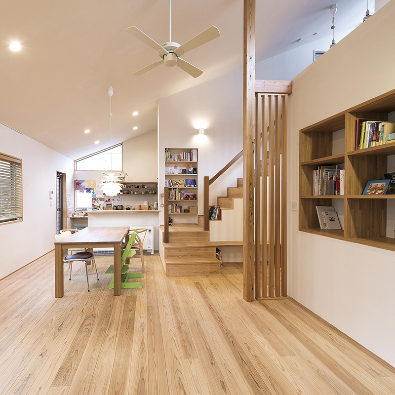 斉藤工務店｜木の温もりが感じられる広々としたLDK。吹き抜けの階段と収納が統一感を持たせ、家族の団らんに最適な場所を提供している。