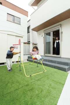 人工芝を敷いた庭で、ブランコやバスケを楽しむ