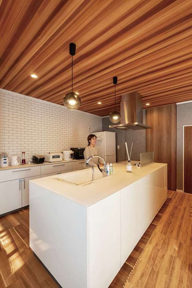 使いやすさと動きやすさを意識したアイランドキッチン。2人で料理しても十分な広さと、動線として前後左右を通る時にストレスにならない幅感を意識。背面はキッチン家電を使いやすく一列に並べた