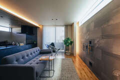 テレビの背面は調湿性に優れたエコカラットに。調光機能付きの間接照明を採用しているので、シーンに合わせて空間の雰囲気を変えられる