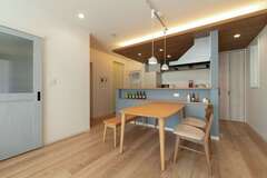 ペールブルーの腰壁と間接照明付きの下り天井によって、カフェ風にコーディネートしたダイニングキッチン