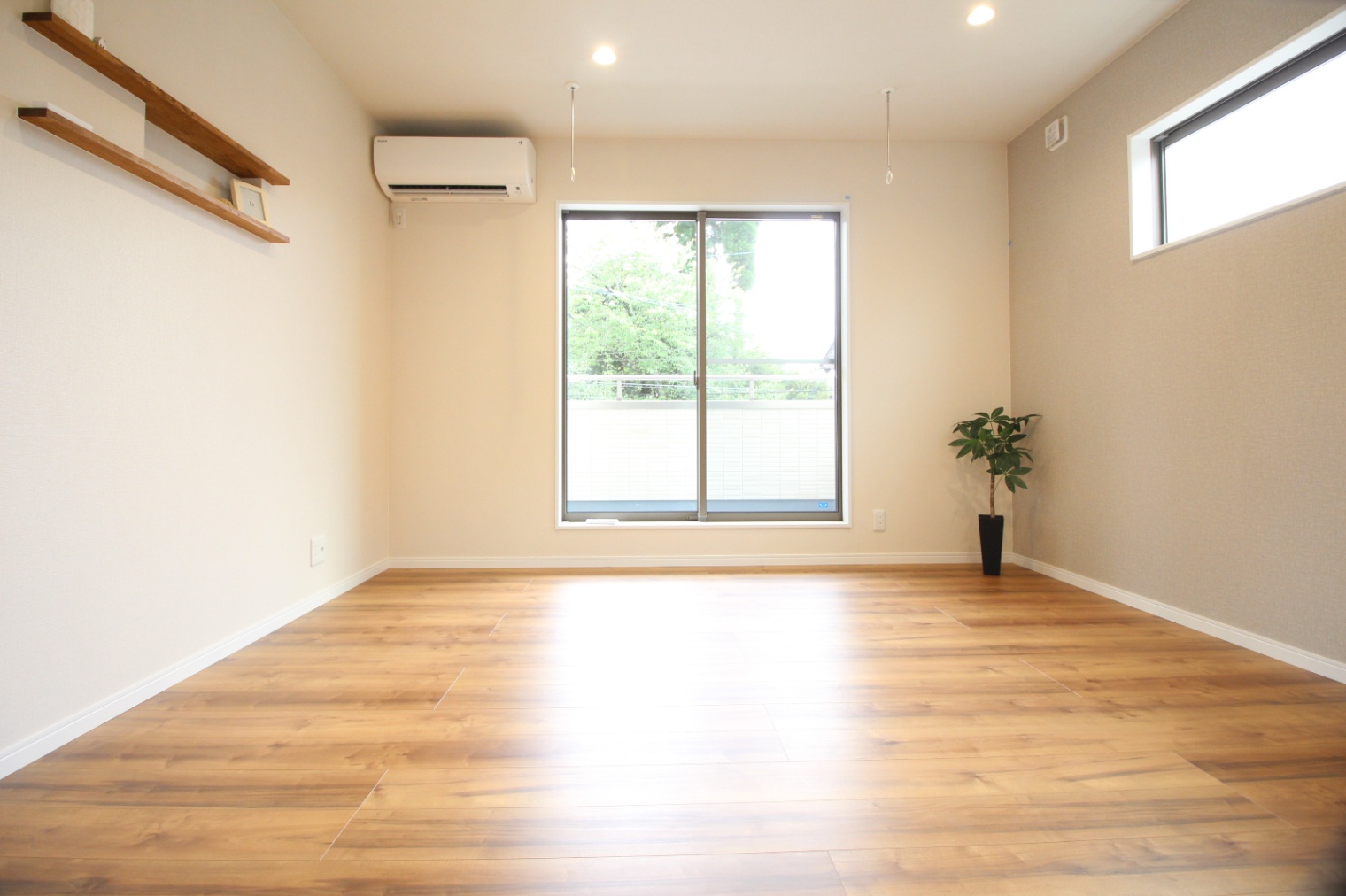 小野田産業～designers house project～｜大きな窓から自然光がたっぷり入る子世帯の居室スペース。落ち着いたフローリングの色合いが居心地の良い空間を演出している。シンプルで洗練された室内デザインが特徴的。