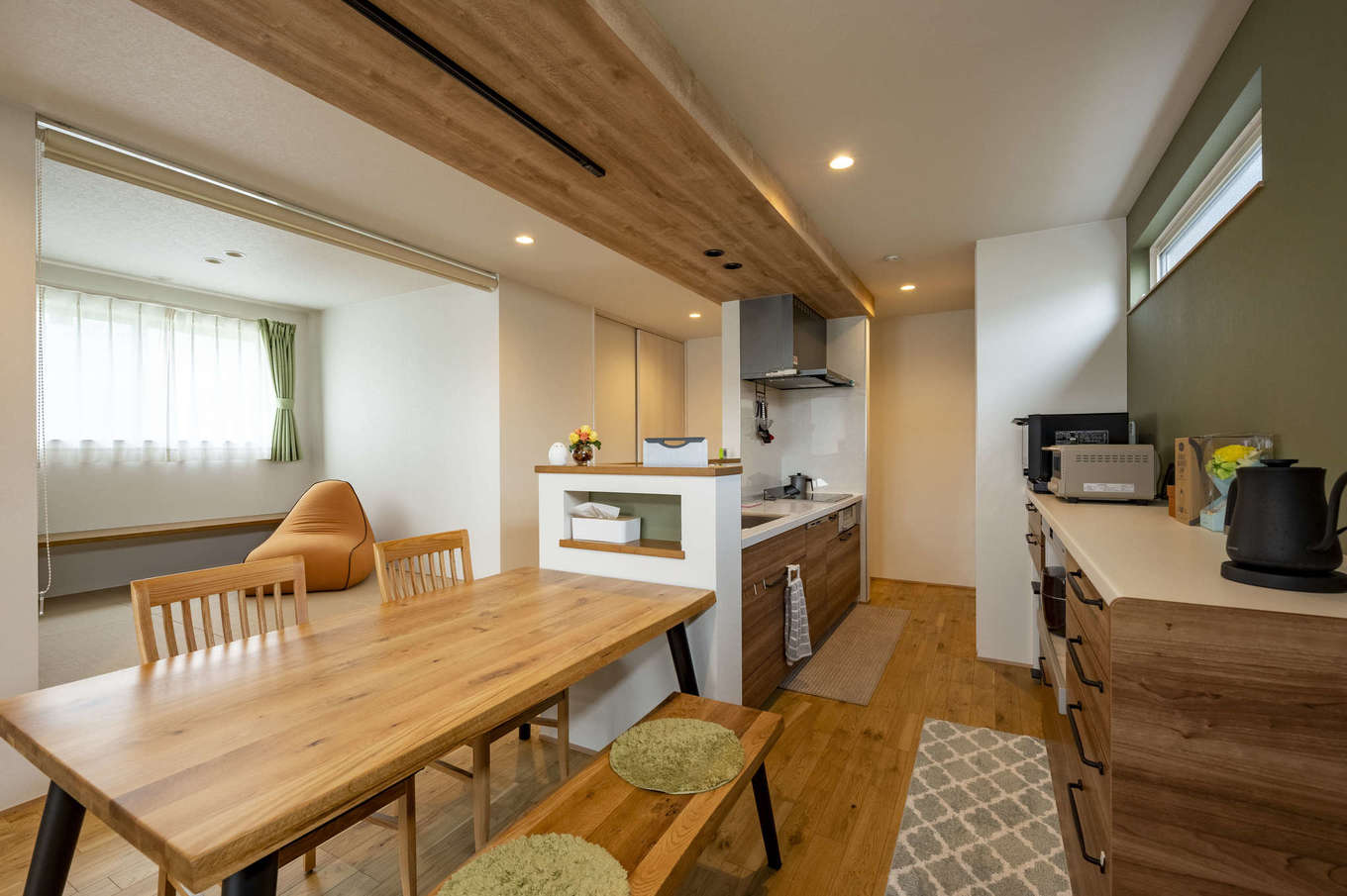 AQURA HOME（アキュラホーム）【収納力、省エネ、間取り】横長の土地形状に合わせて、ダイニングテーブルをキッチンの横に配置。配膳も片付けもラクになった。キッチンの腰壁にティシュBOXを置いたり、スマホを充電したりするためのニッチを造作