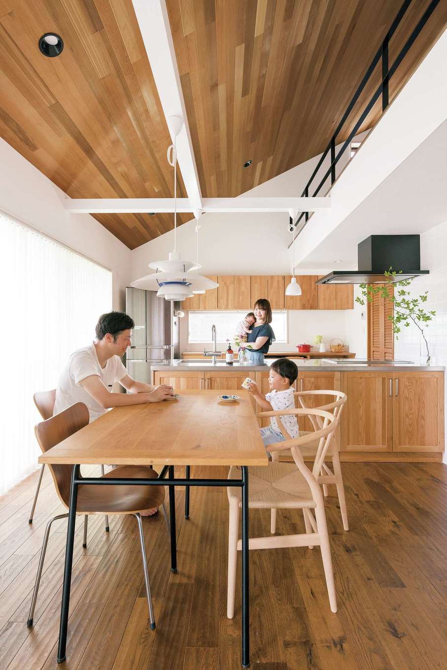 nattoku住宅｜ミニキッチン付きの2階洋室を開放感あふれるLDKに。ウエスタンレッドシダーの天井に合わせて、キッチンとカップボードも木目調に。インテリアはポールセンのペンダントライト、Yチェアなどで北欧テイストにコーディネートした
