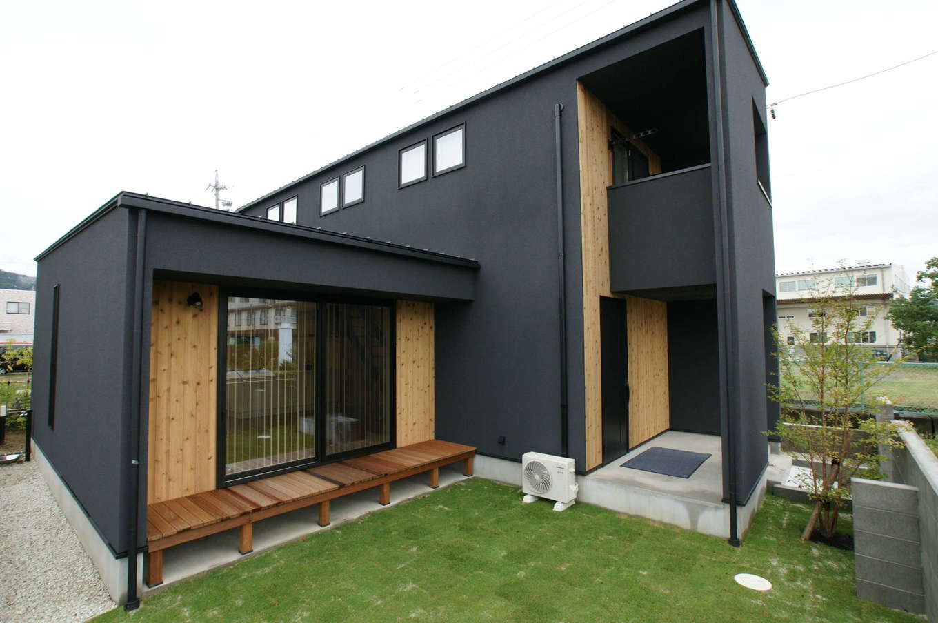 RIKYU 一級建築士事務所【デザイン住宅、間取り、建築家】ブラックのサイディングと無垢板がバランス良く調和した外観デザイン。抜け感のあるポーチが建築家住宅らしさを思わせる。リビングの窓を開けると中庭との一体感が生まれ、より開放的な雰囲気に