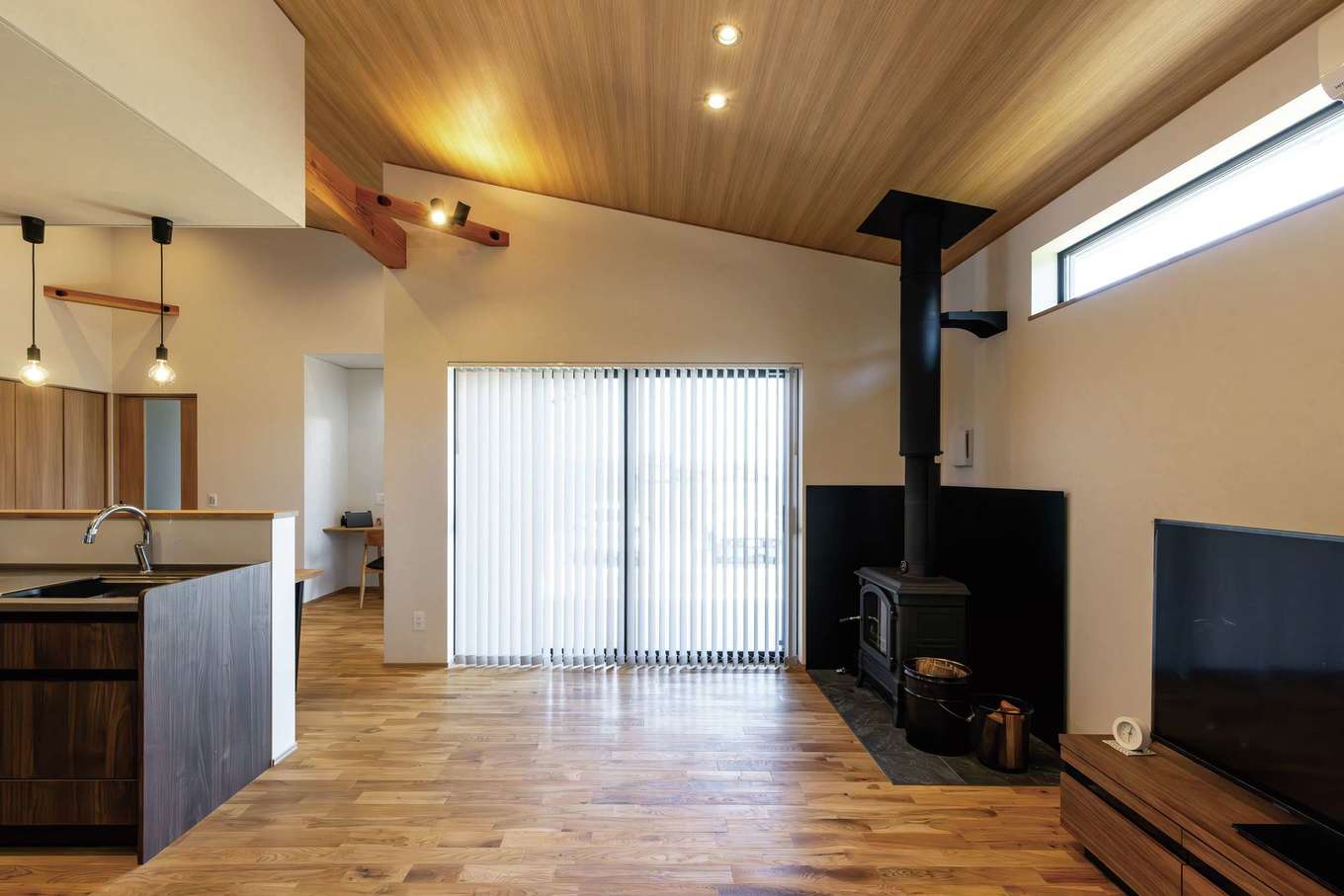 神谷綜合建設 カミヤの家【子育て、省エネ、平屋】ネスターマーティン製の薪ストーブが目を引くリビング。冬場はこれ1台で家中ポカポカ。隣家のある南面は高窓だけとし、東の大きな窓が室内に明かりを届ける