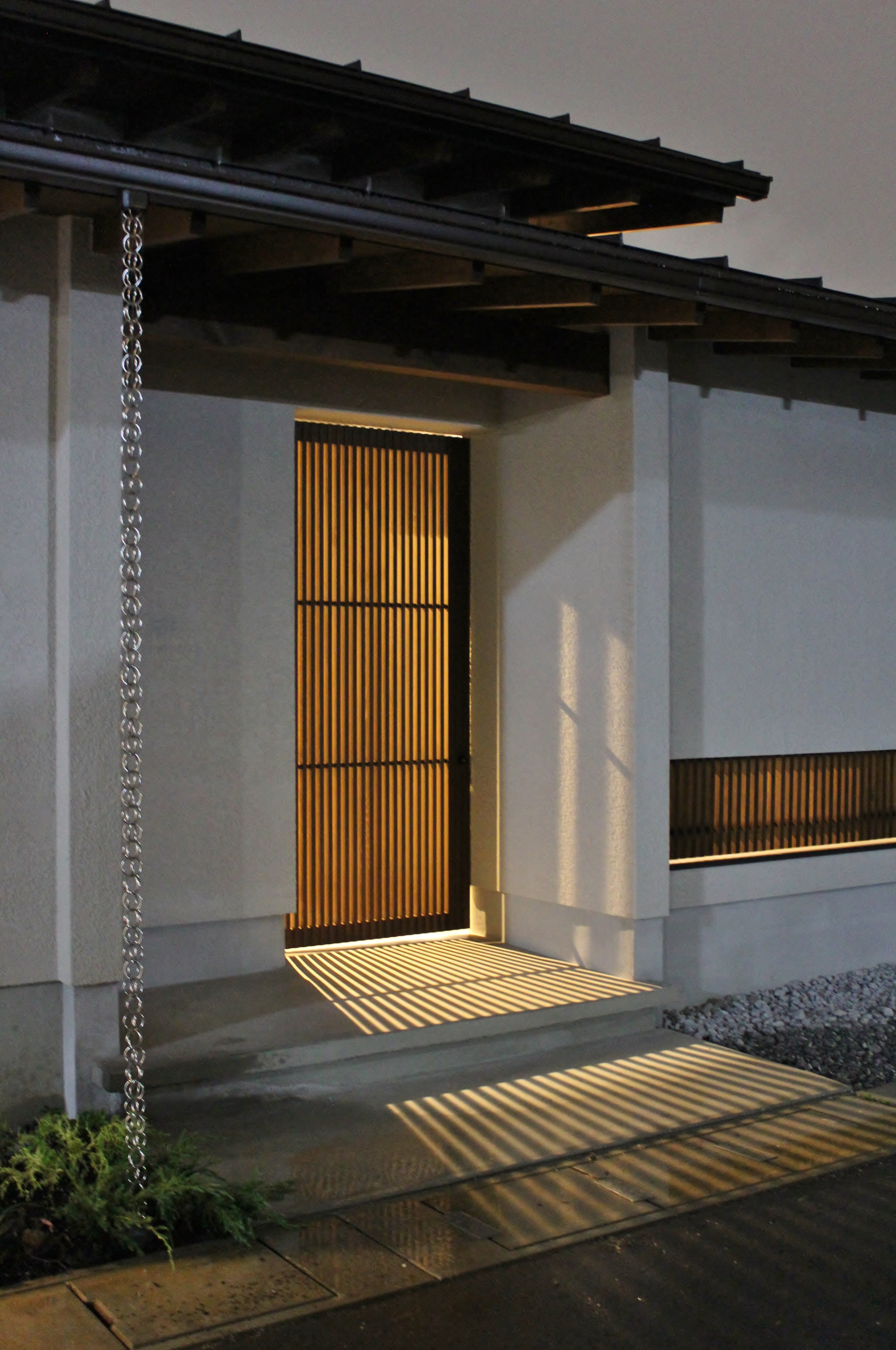 安田住宅｜安田建築設計室｜格子状の引戸から優しい光と影が演出している。ディンプルキーを設け、防犯対策としても有効なアプローチ上の門扉。