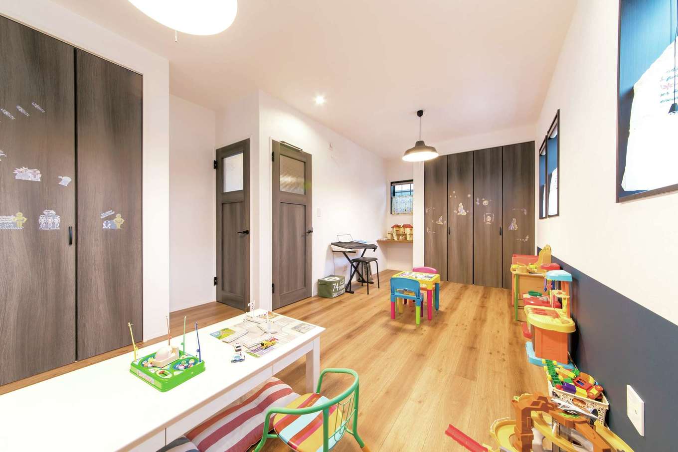 三和建設【子育て、収納力、自然素材】子ども部屋は二間続きで。シックな色調のクロスを腰壁のように用いてアクセントに。ドアやクローゼット扉も同系色でまとめている