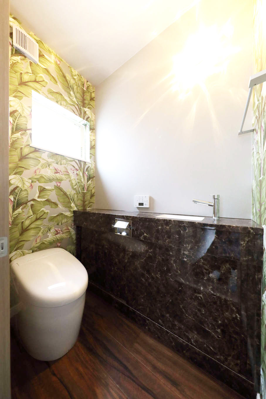 トーリンホーム【デザイン住宅、高級住宅、インテリア】2階の住居スペースに設けたトイレ。広さに余裕を持たせ、カウンターも設置。アクセントクロスで個性の彩りをプラス
