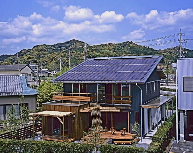 アクトホーム【自然素材、省エネ、建築家】ガルバリウム鋼板とウッドサイディングのコントラストが美しい外観。屋根の上には太陽光発電パネルと太陽熱暖房のWソーラーシステム