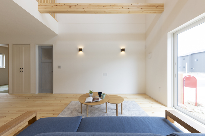 大きな窓から光が差し込む広々としたリビング。ナチュラルな木材が暖かみを演出し、落ち着いた雰囲気を提供する空間である。