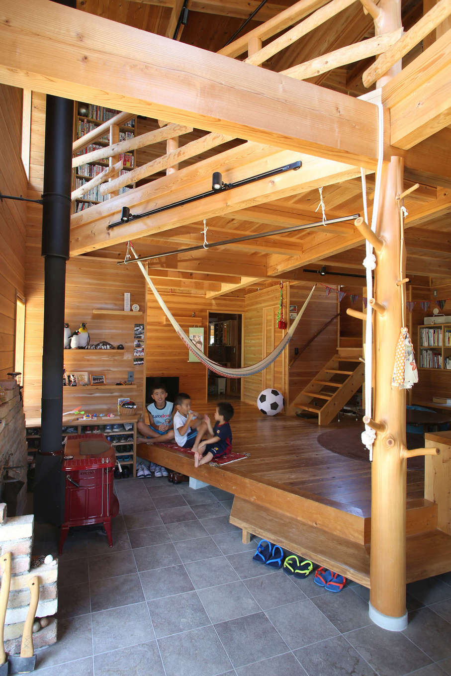 有吉住宅【子育て、趣味、自然素材】玄関続きの土間スペースは、ご近所さんとのコミュニケーションの場にもなる。リビングの天井のあちこちにフックをつけて、ハンモックやロープを吊り下げられるようになっている