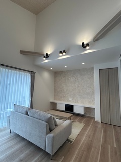 窓からの光が差し込む明るいリビング。壁面の色合いが柔らかく、心地よい雰囲気を演出する。収納スペースも十分に確保されている。