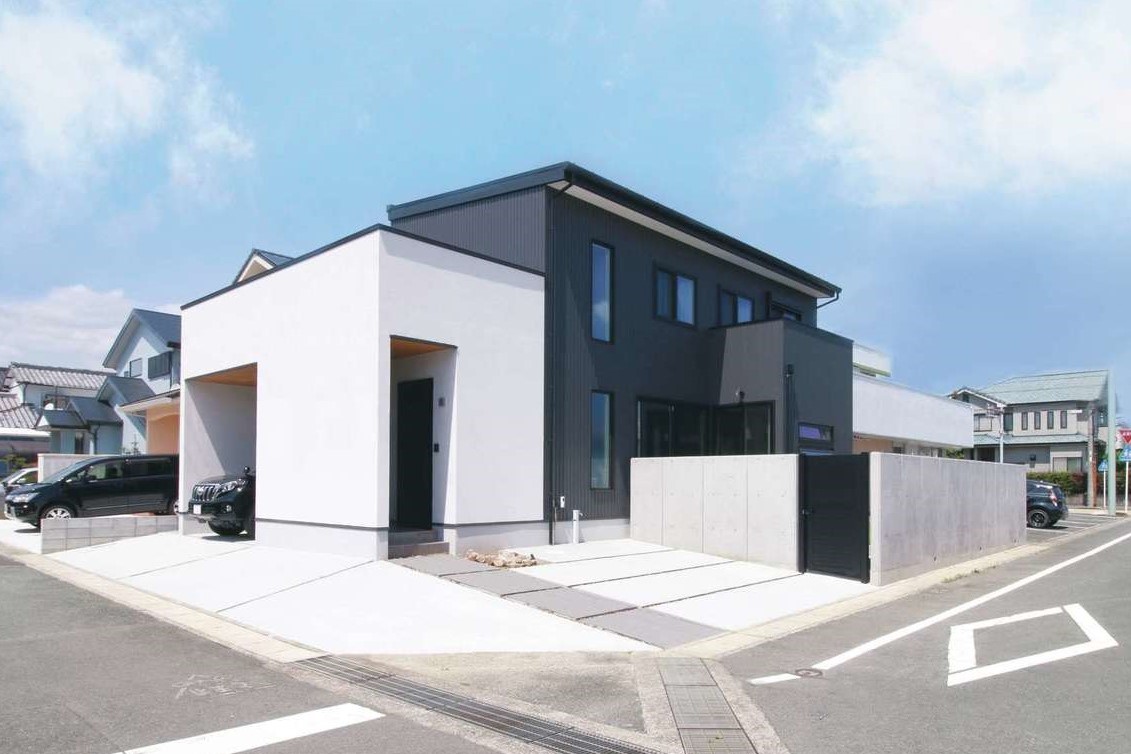 コットンハウス【デザイン住宅、省エネ、間取り】白い塗り壁とグレーのガルバリウム鋼板の外壁を組み合わせた外観。周囲をフェンスで囲み、プライベート感あふれる庭を実現