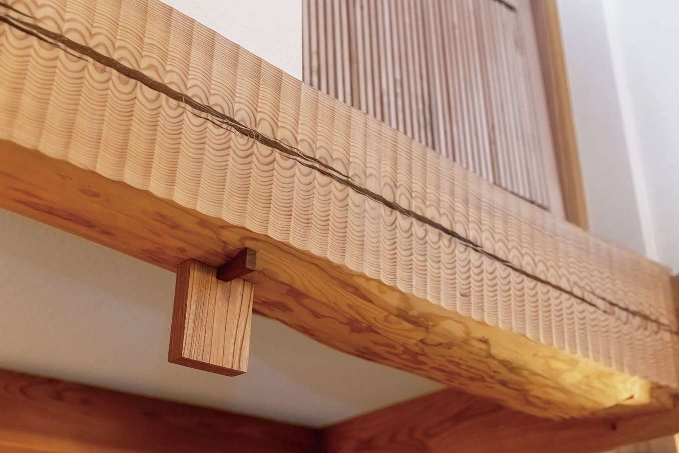 石牧建築【趣味、自然素材、省エネ】T邸のシンボルともいえる太い松の太鼓梁。同社の若い社員大工が、手刻みと名栗（なぐり）加工で丁寧に仕上げた。他にも大工の美しい伝統技が随所に