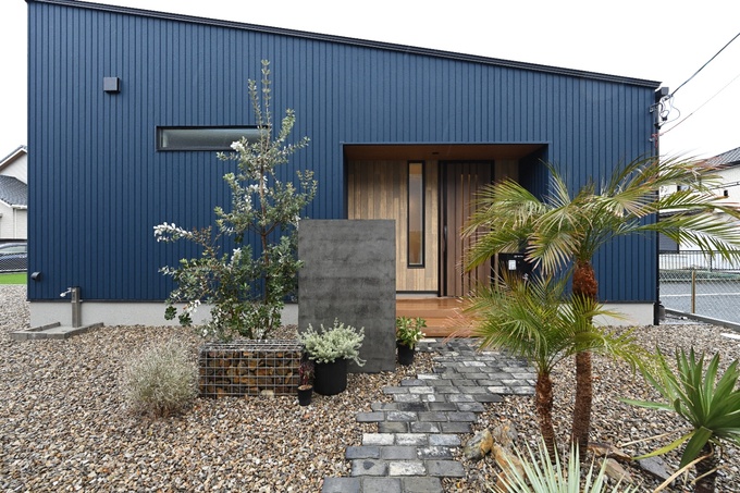 スタイリッシュな玄関。植物が配置されたアプローチが、訪れる客を気持ちよく迎えるデザイン。