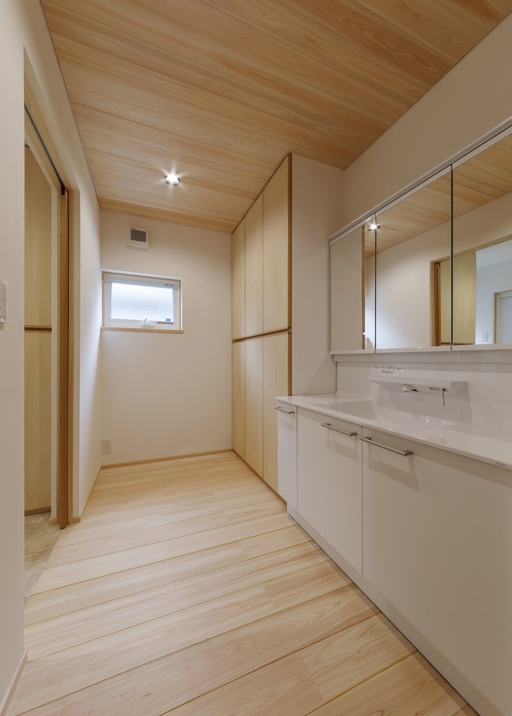 灯建築舎【デザイン住宅、和風、自然素材】脱衣室と分離し、利便性を高めた洗面コーナー。造作の収納は、容量も使い勝手も申し分なし。I邸のほとんどの扉は、壁の中にすっぽりと納まる引き込み戸が採用されている