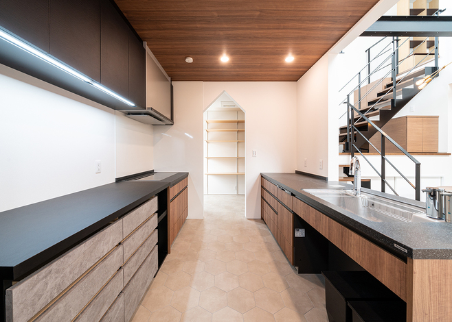 フロア全体を見渡せるキッチン。三角屋根の形状に切り取ったパントリーが、収納力と使いやすさ、視覚的な印象を高めている