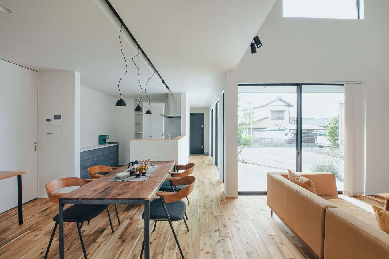 S.CONNECT（エスコネクト）【デザイン住宅、狭小住宅、建築家】明るい自然光が届くLDKは、L字型の部屋の角に窓を集めることで外への広がりを演出。アカシアの無垢フローリングも柔らかな印象の住まいによく似合う。この開放感で気密性はC値  0.29というから驚きだ