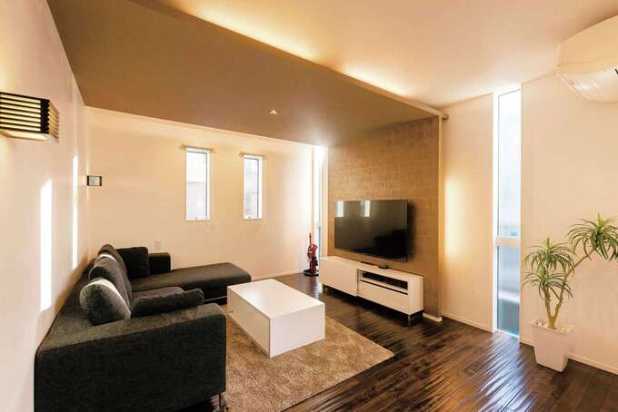 デコボコ感が気持ちいい無垢の床、L字型のソファ、コーヒーテーブル、AVボードはすべて『納得』オリジナル。調湿効果の高い漆喰の塗り壁、断熱材のセルロースファイバーも標準仕様