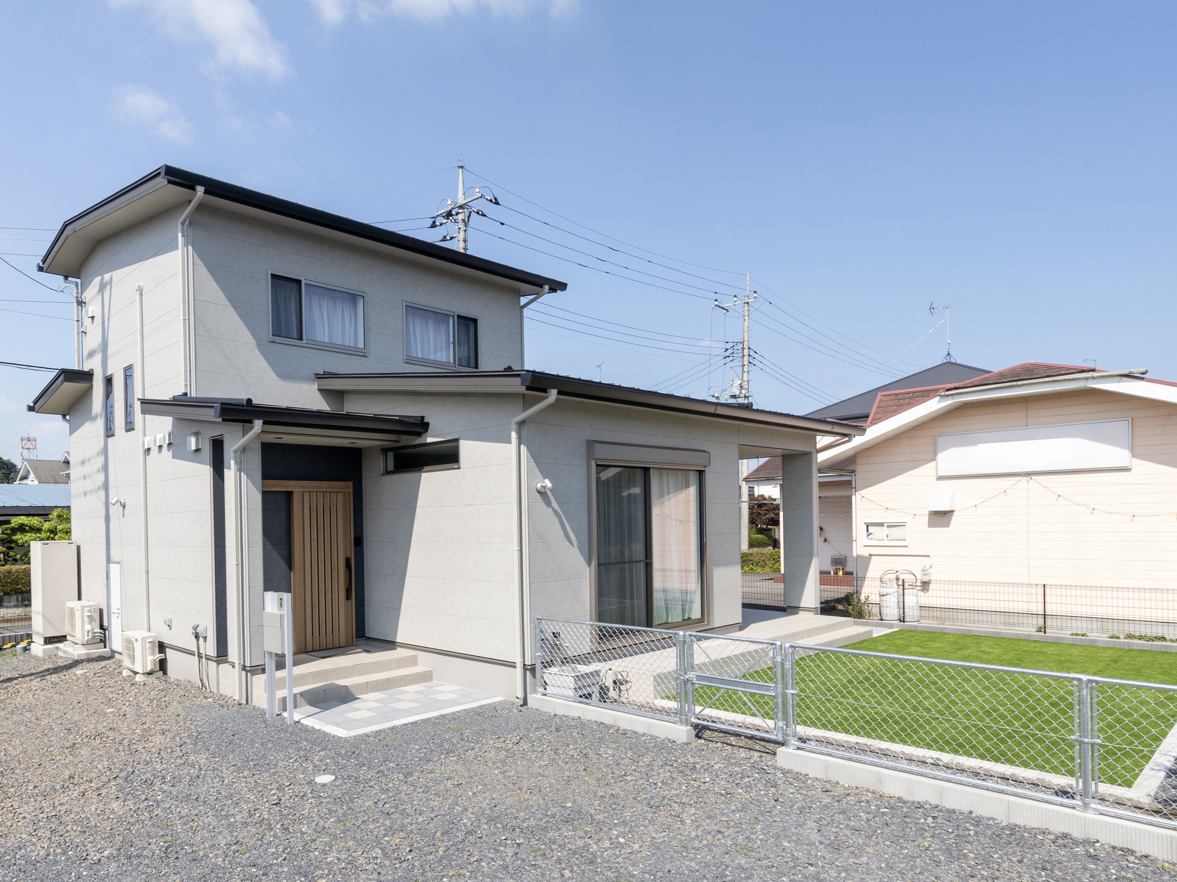 エスホーム｜グレーの外壁は、目地のコーキングがないシームレスタイプのサイディングは、痛みづらいのでメンテナンス費用が節約できる。庭と駐車スペースをたっぷり確保してバーベキューなど様々な用途に使える。