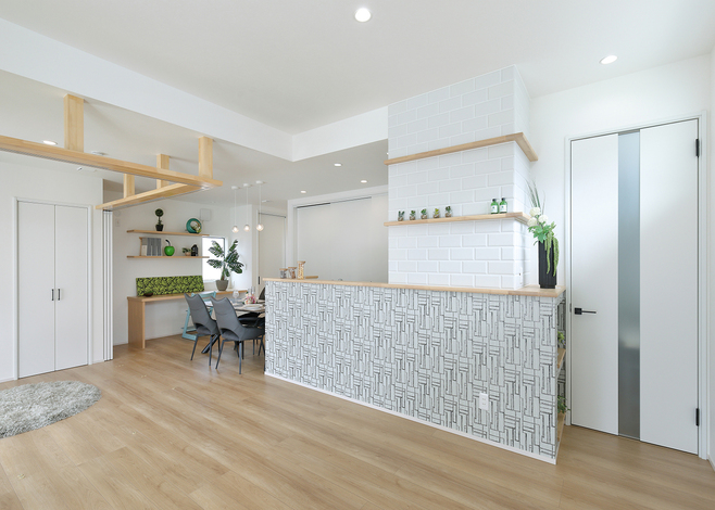 キッチン腰壁のアクセントクロスが印象付けるLDK。フリースペースの建具を開けた状態だと広々とした空間になる