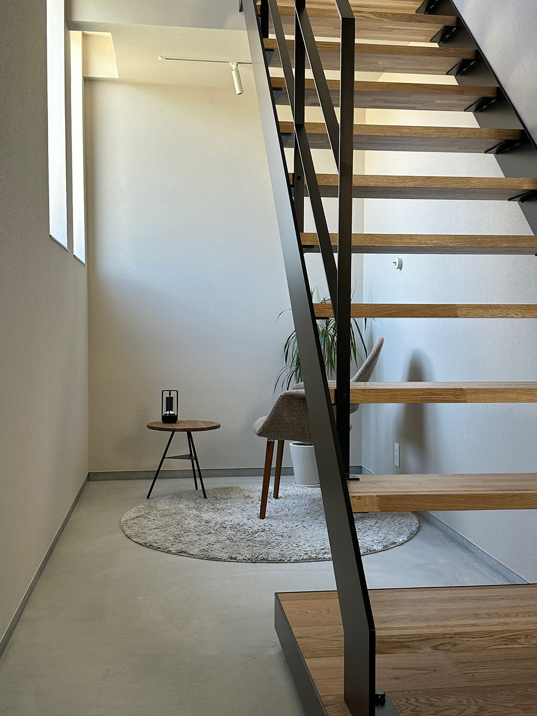 BASE.trip【デザイン住宅、間取り、インテリア】趣味で革製品を作る奥さまの要望で、玄関に広い土間を設けて2.5畳の作業場＆展示スペースを確保。吹抜けを採用し、階段もスケルトンにしたことで玄関ホールに開放感が生まれた