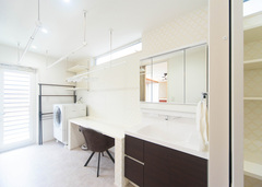 広さのある洗面兼ランドリールーム。洗濯物干と作業台が取り付けてあるため、室内干しやアイロンまでこの部屋で行うことができる。更にここからテラスにも行き来することも可能