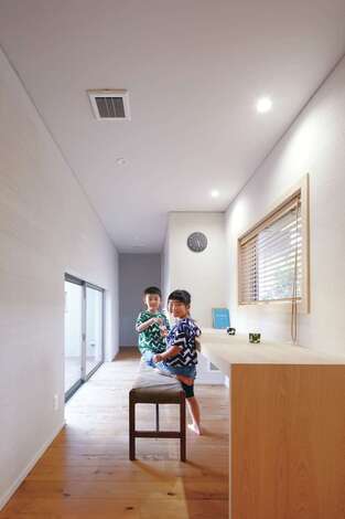 2棟の平屋をつなぐ渡り廊下に家族共有のカウンターを造作