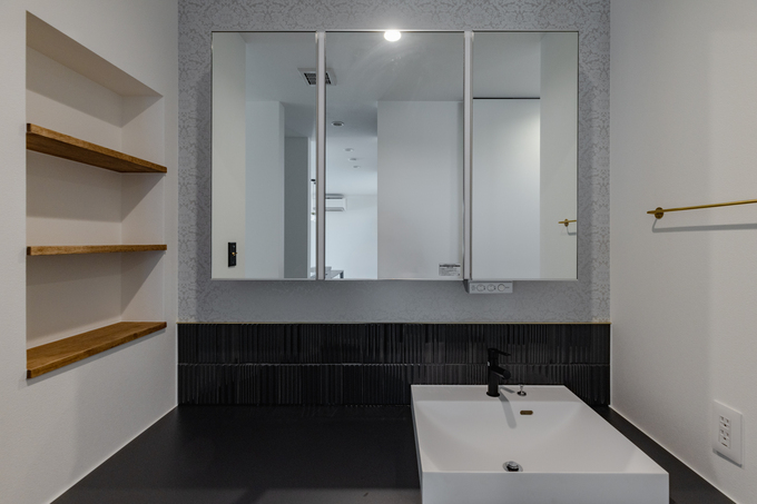 モダンなデザインの洗面スペース。このスペースにはシンプルな洗面台と収納棚を設置し、実用性と美しさを兼ね備えている。