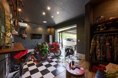 大切なバイクをディスプレイするバイクガレージ。収納スペースやリラックスできる小さな座席もあり、スタイルと機能性を両立。