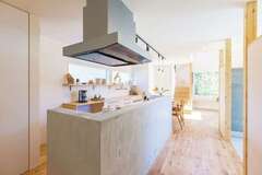 玄関土間の正面にあるキッチン。アイランド型にして、グルグル回れる動線を確保。既成のキッチンをモルタルで覆うことで、まるでオリジナルキッチンのように見える